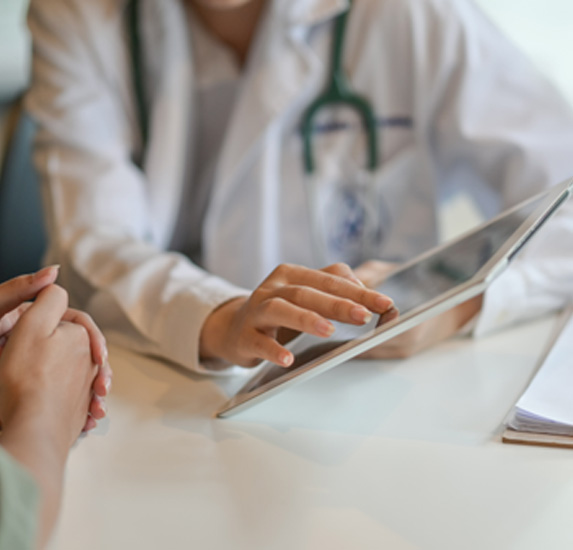 A doctor showing information to a patient via tablet