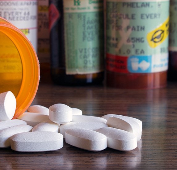 A spilled bottle of opioids on a counter top