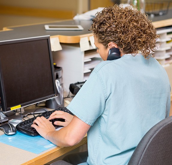 A young receptionist working at her computer
