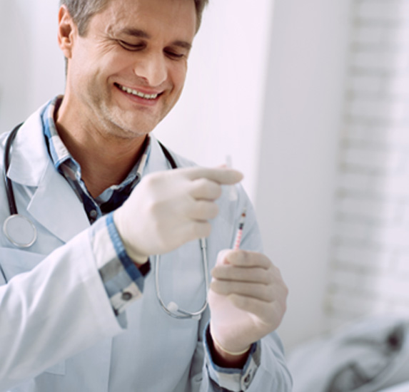 A doctor preparing a syringe for an injection treatment