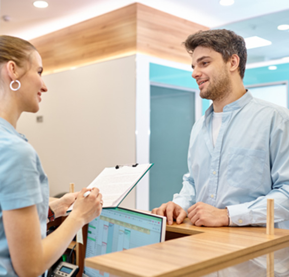 A man talking to a healthcare receptionist