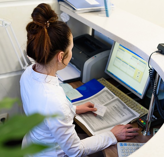 A healthcare receptionist working at her computer